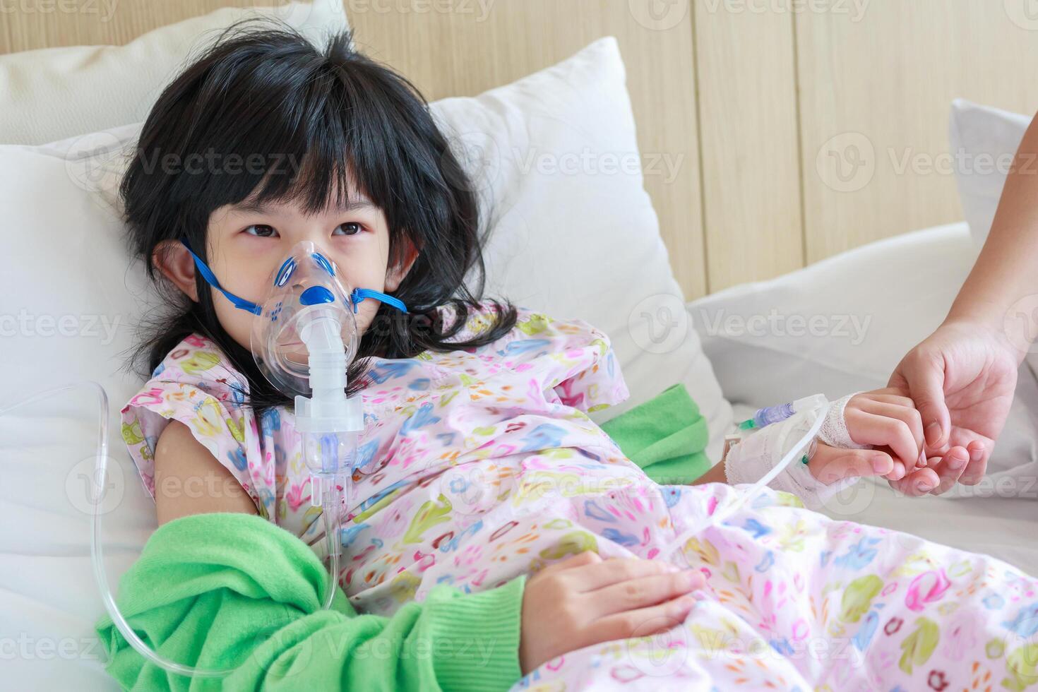 Sick little asian girl inhalation with nebulizer for respiratory treatment photo