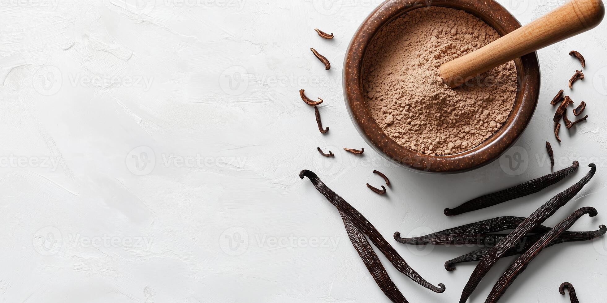 Vanilla powder in a mortar with pestle next to whole beans photo