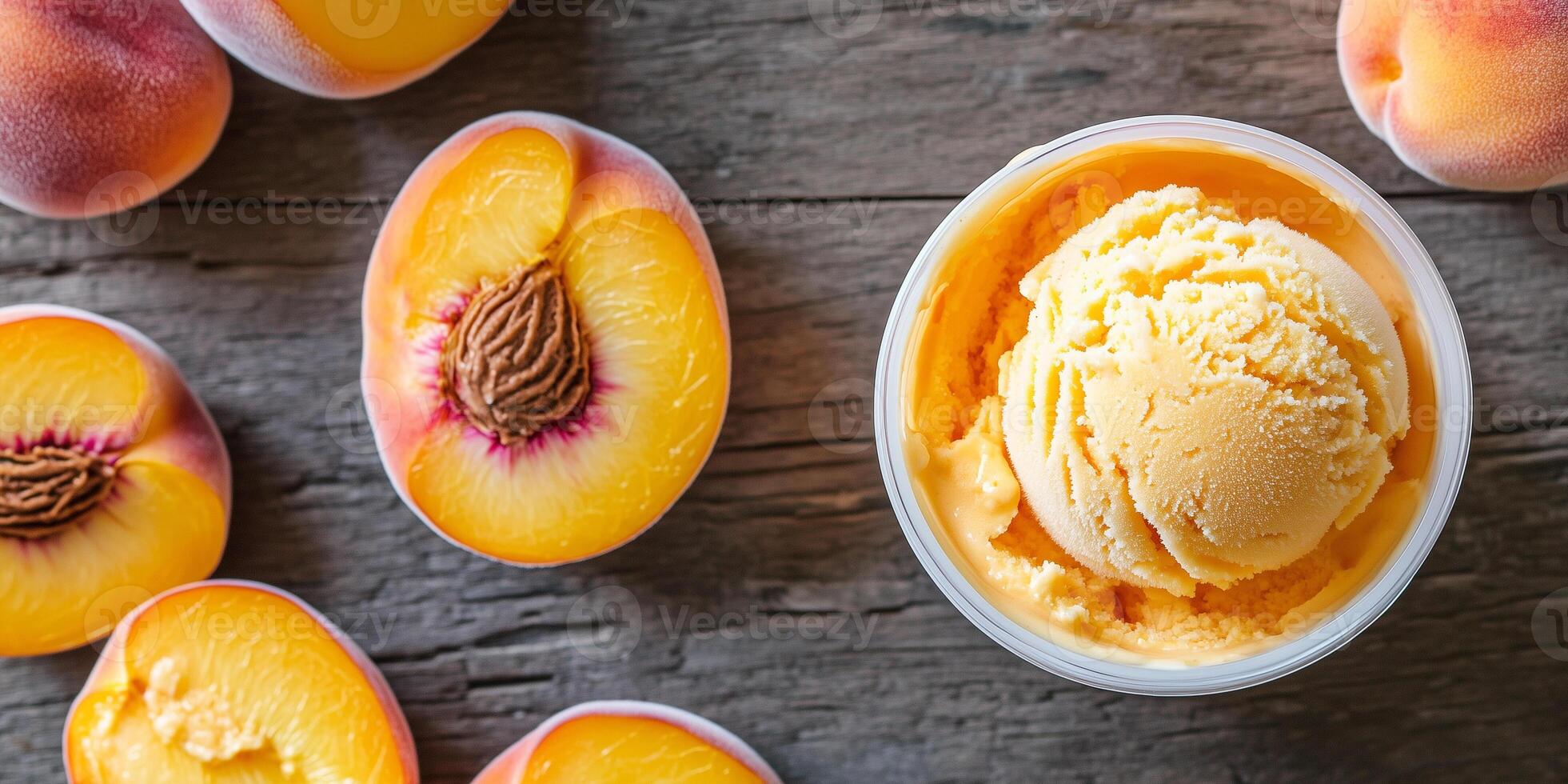 Peaches sliced open next to container of orange-hued ice cream photo