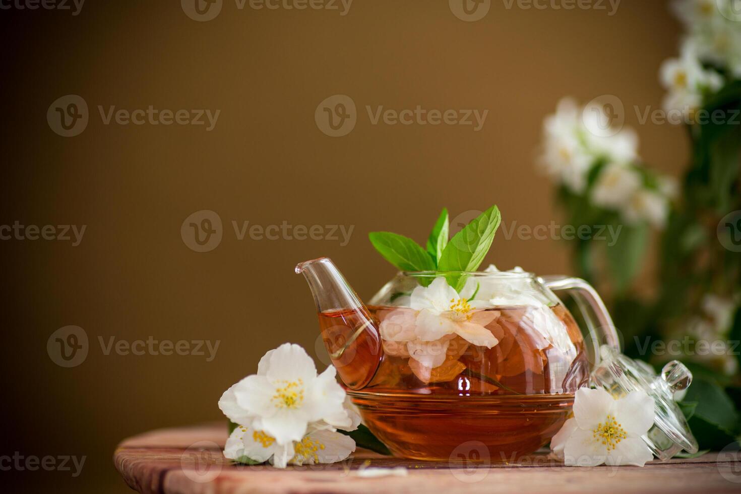 jasmine flower tea in a glass teapot.On a wooden table photo