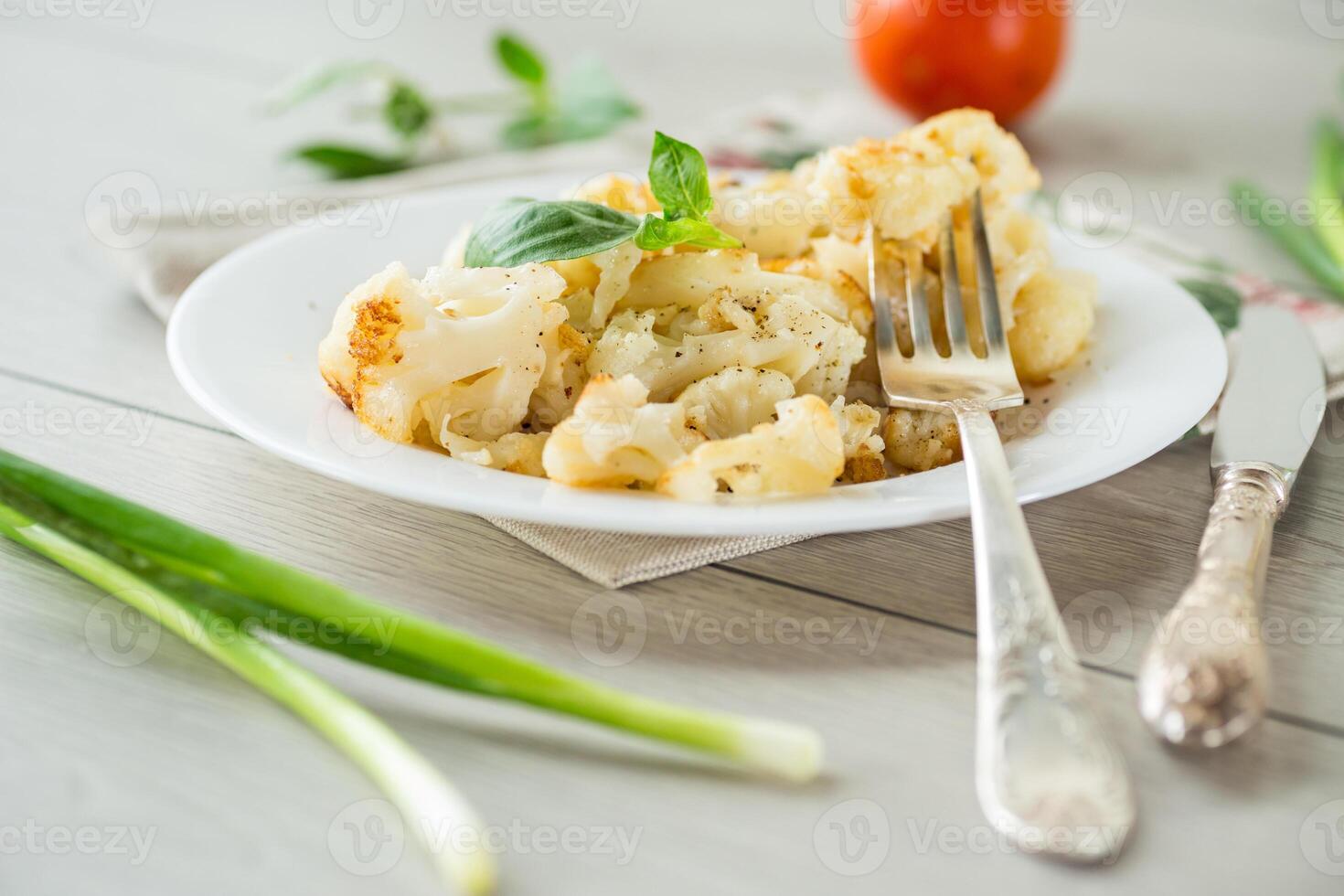 fried diet cauliflower cooked in a plate on a wooden table photo