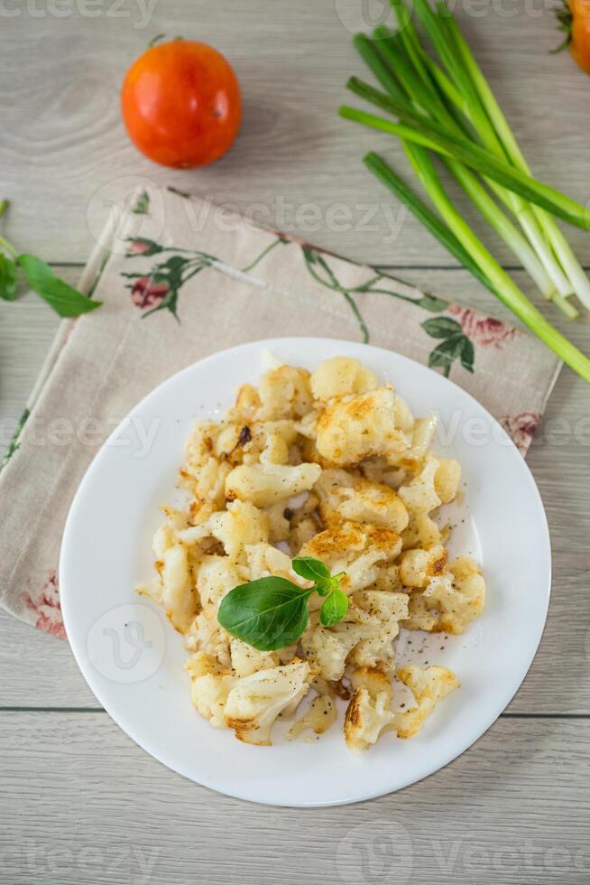 fried diet cauliflower cooked in a plate on a wooden table photo