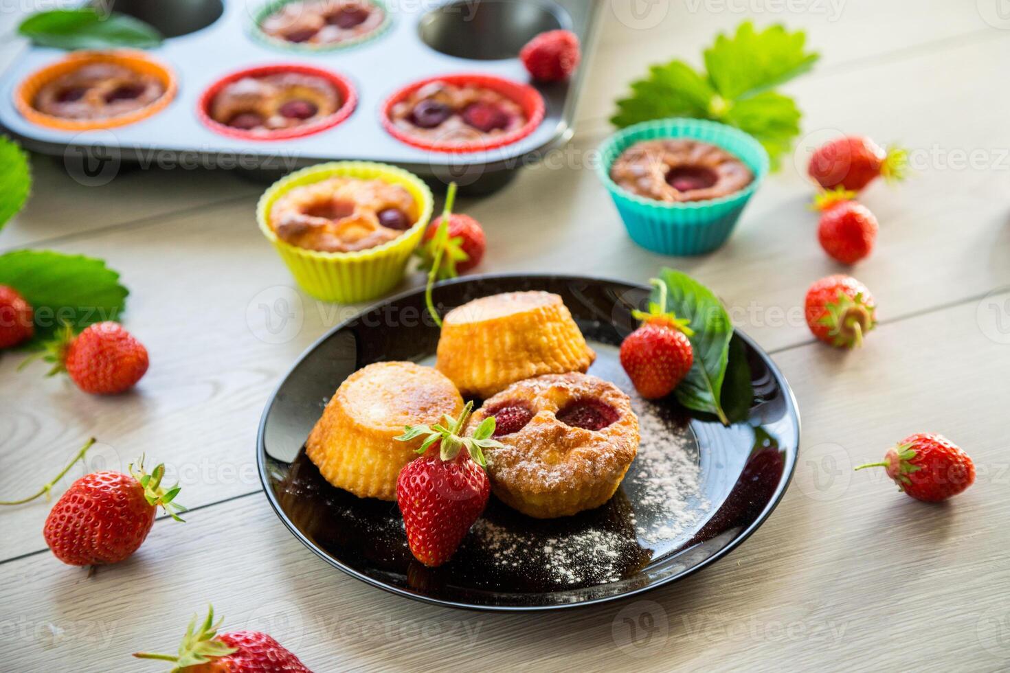 Sweet curd muffins with strawberry filling.On a wooden table photo