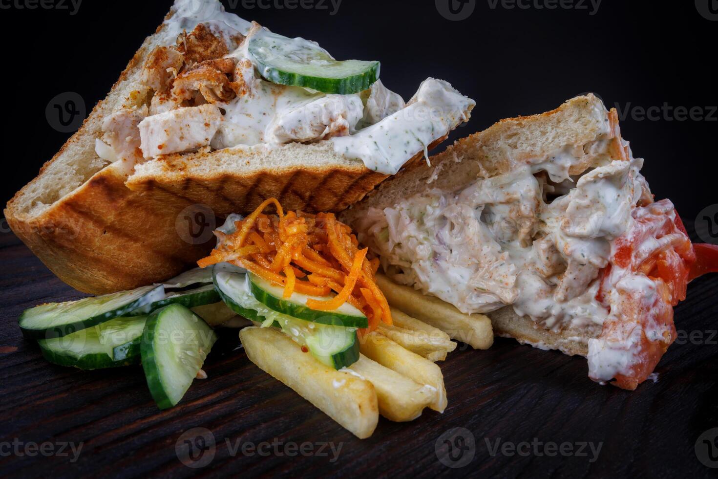 Cut doner with a crispy crust and delicious meat and vegetable filling on a dark background. photo