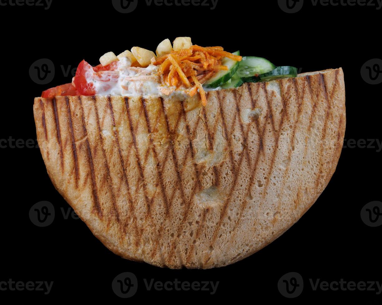 Doner with a crispy crust and delicious meat and vegetable filling on a dark background. photo