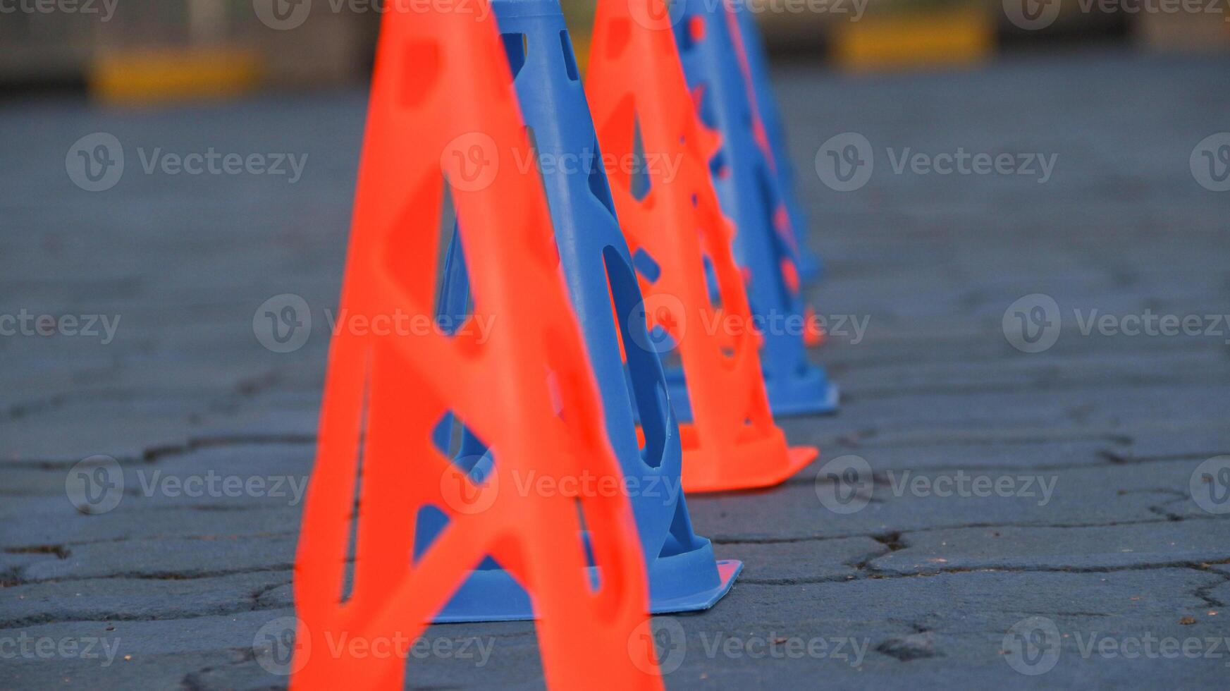 Orange cones and blue cones set up on a blue field for high school sports speed drills. photo