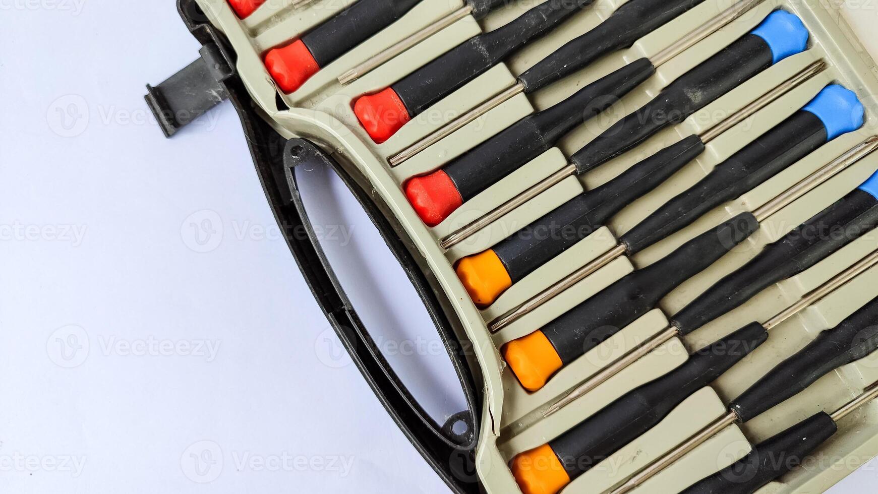Set of red-orange-blue screwdrivers isolated on white background. Builder's and electrician's tools. Equipment. Set of steel screwdriver bits with red and black plastic handles. photo