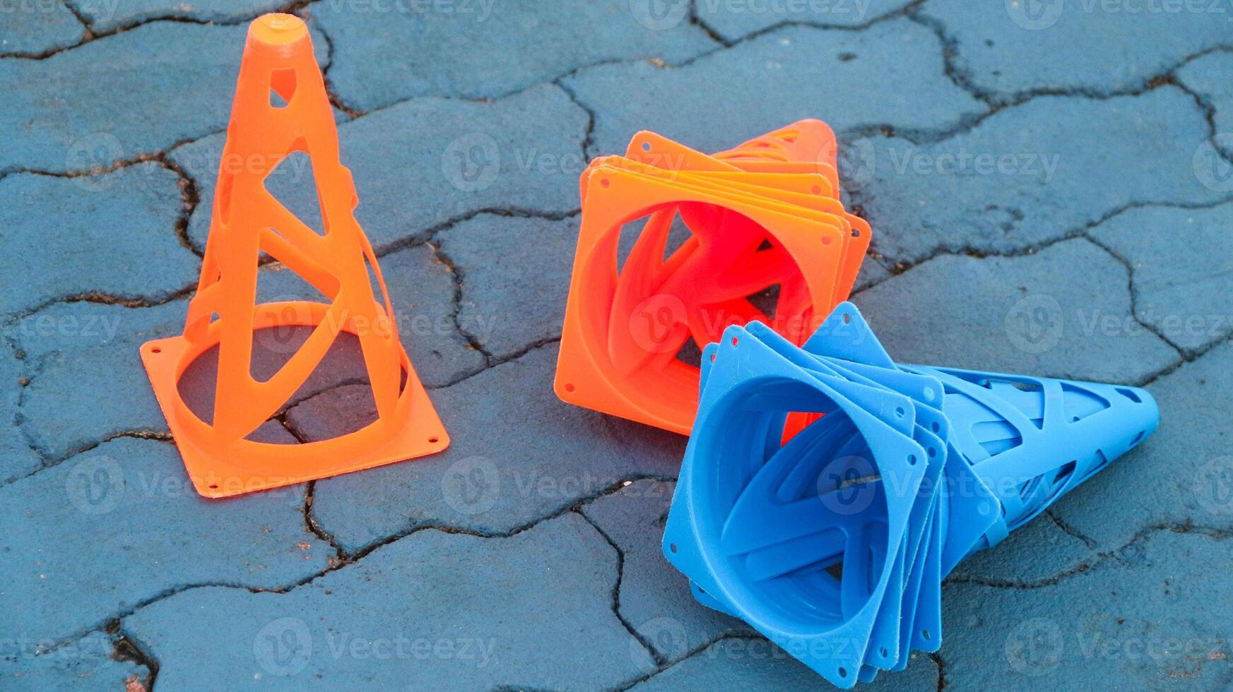 Orange cones and blue cones set up on a blue field for high school sports speed drills. photo