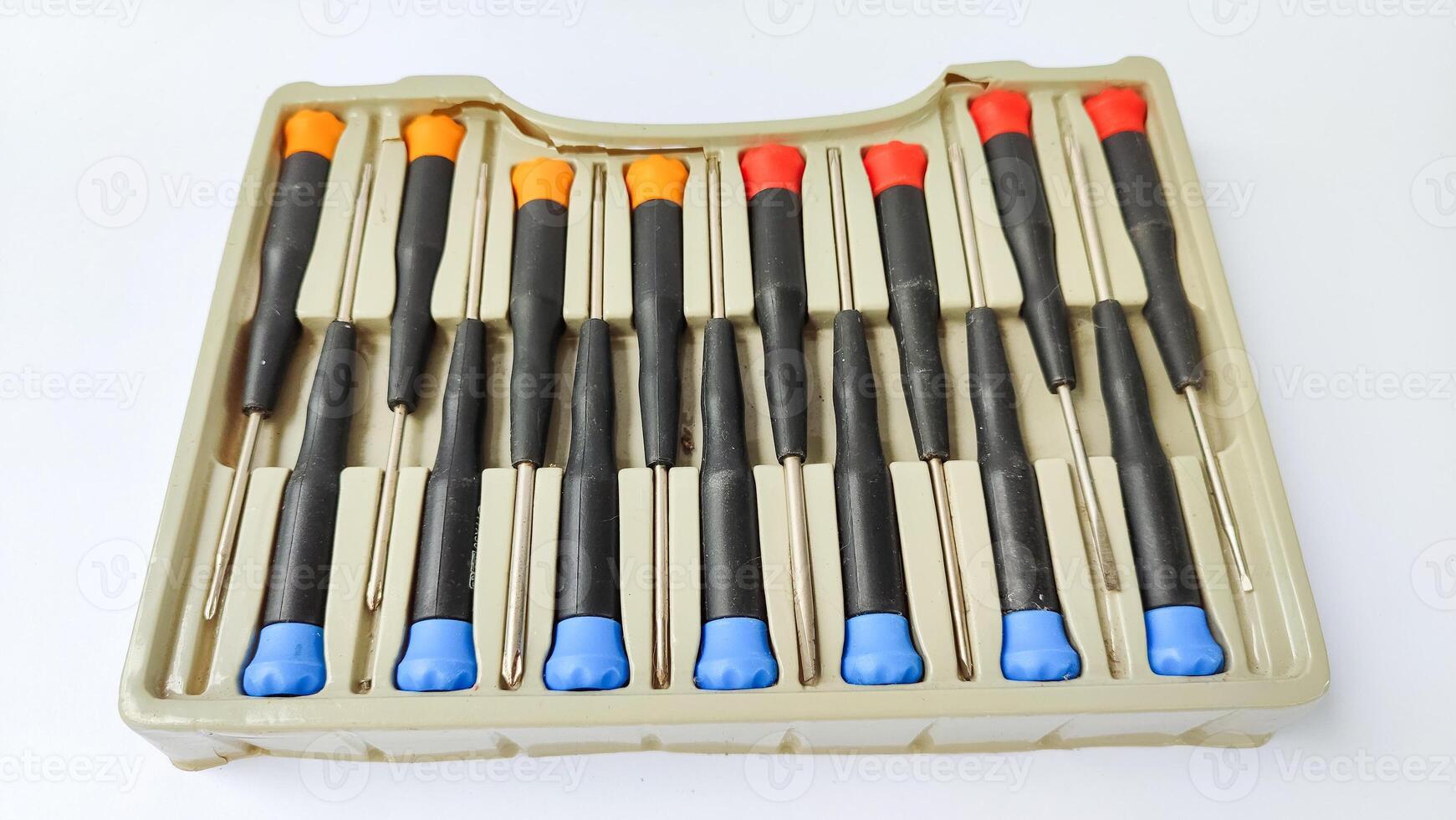Set of red-orange-blue screwdrivers isolated on white background. Builder's and electrician's tools. Equipment. Set of steel screwdriver bits with red and black plastic handles. photo