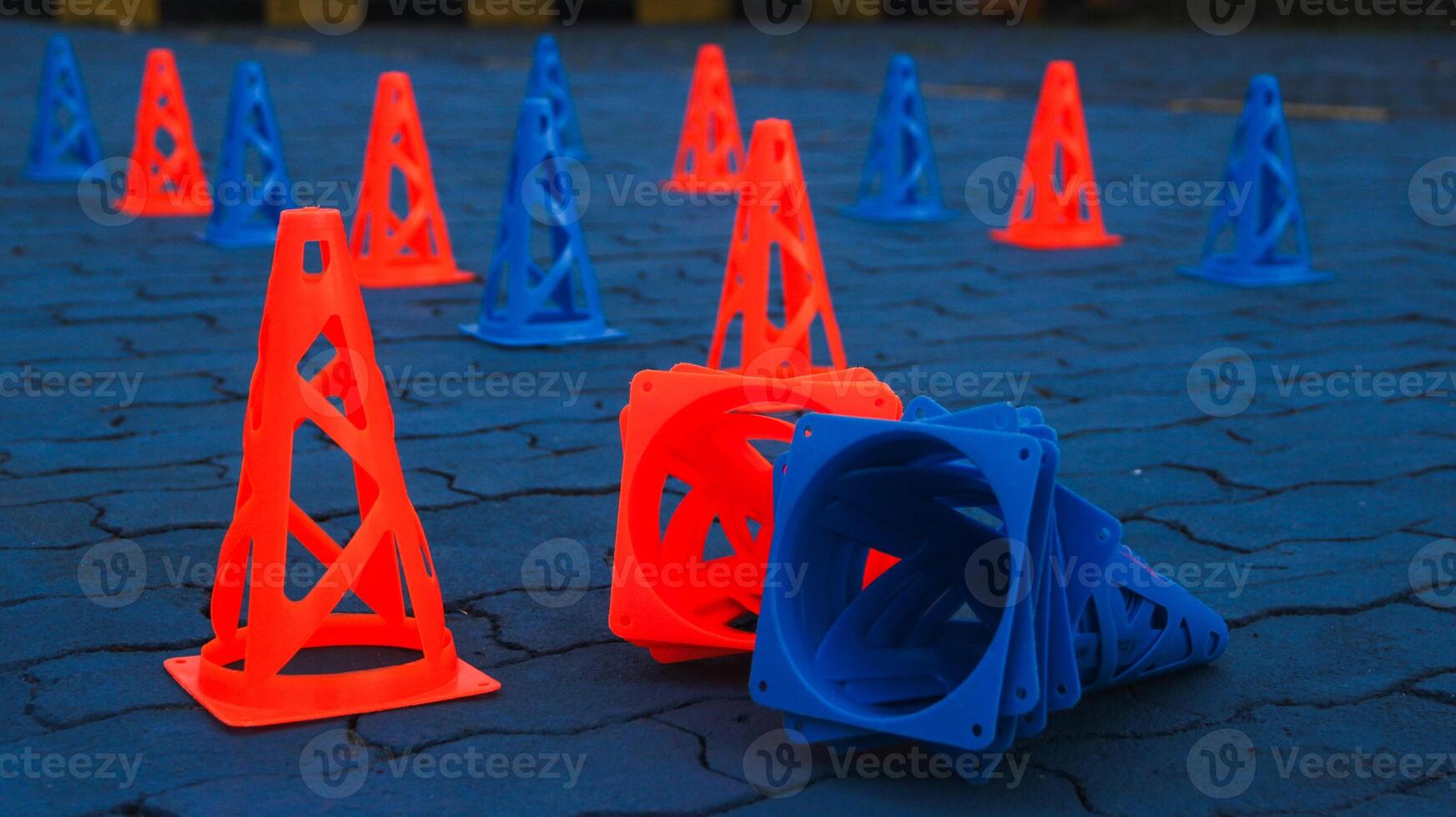 Orange cones and blue cones set up on a blue field for high school sports speed drills. photo