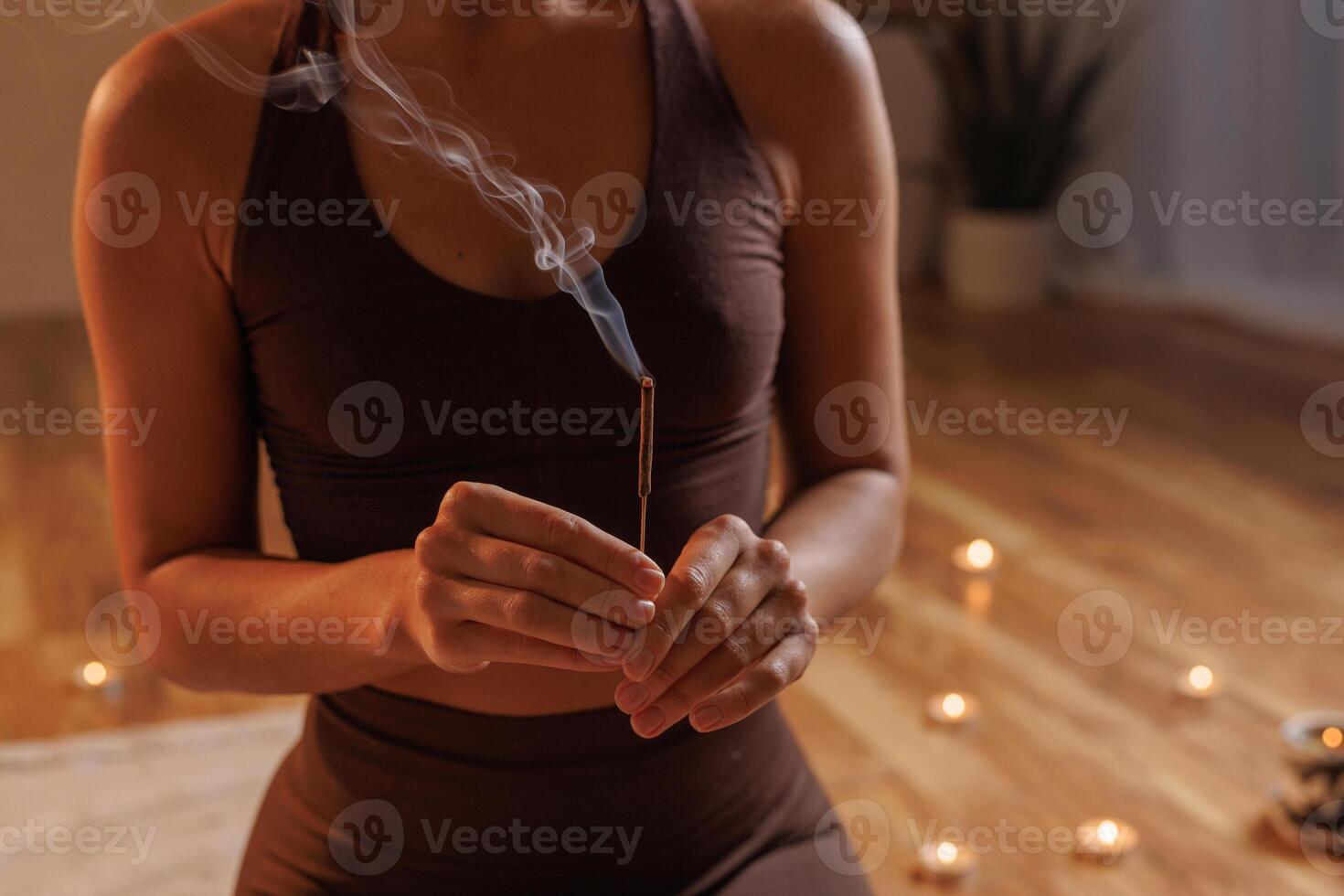 Meditative moment with incense and candles, smoking aroma stick close up. aromatherapy photo