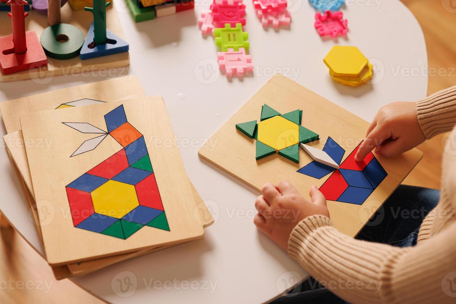Close-up of children's hands playing with an educational multi-colored puzzle toy photo