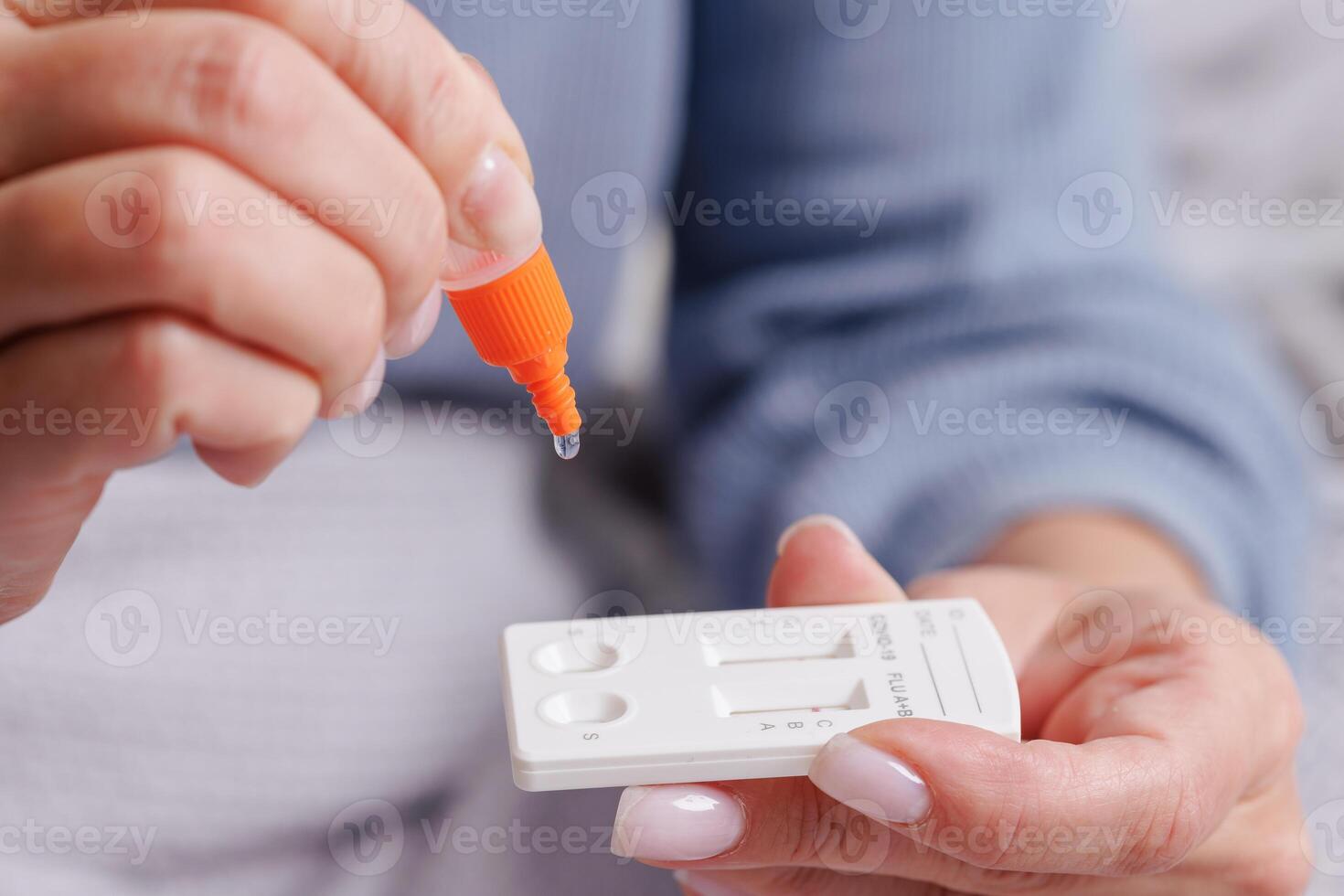 woman tests herself for new strain of coronavirus at home, covid-19 and flu virus test photo