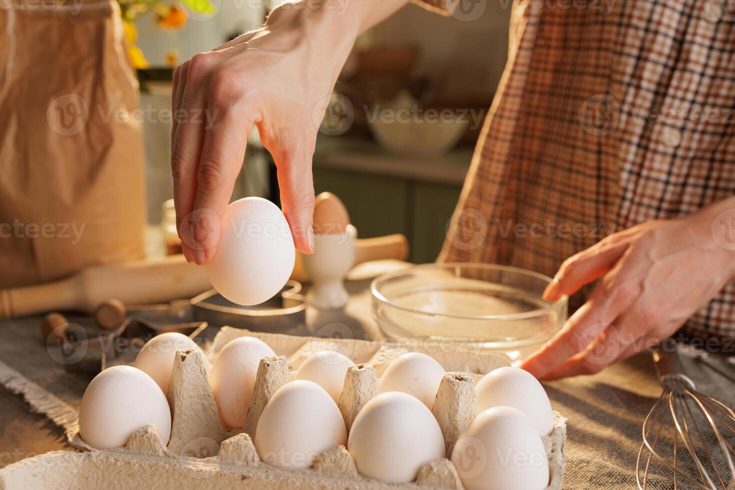 Hand taking out egg from egg carton in kitchen photo