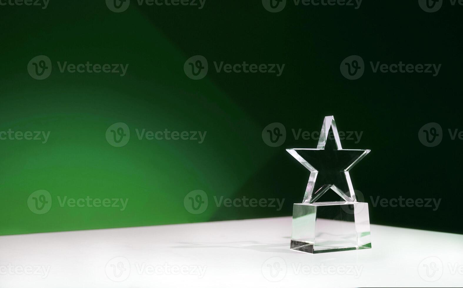 Sustainability award - star-shaped crystal prize on a table with green spotlights and copy space photo