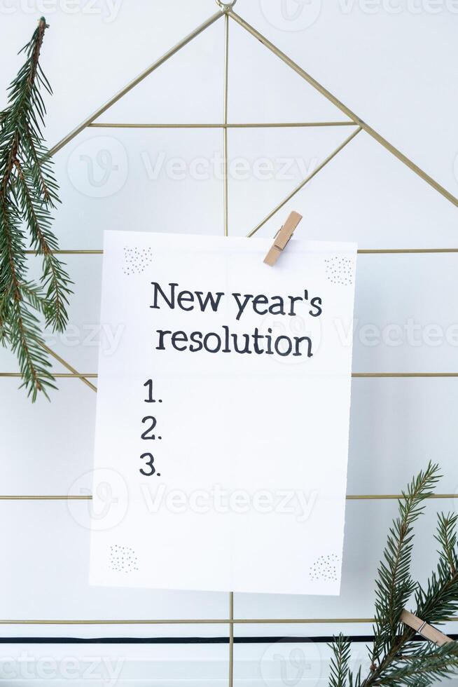Vision board with NEW YEAR'S RESOLUTION aims goals on paper note. Preparation for New Year. Concept of planning and setting goals for personal development photo