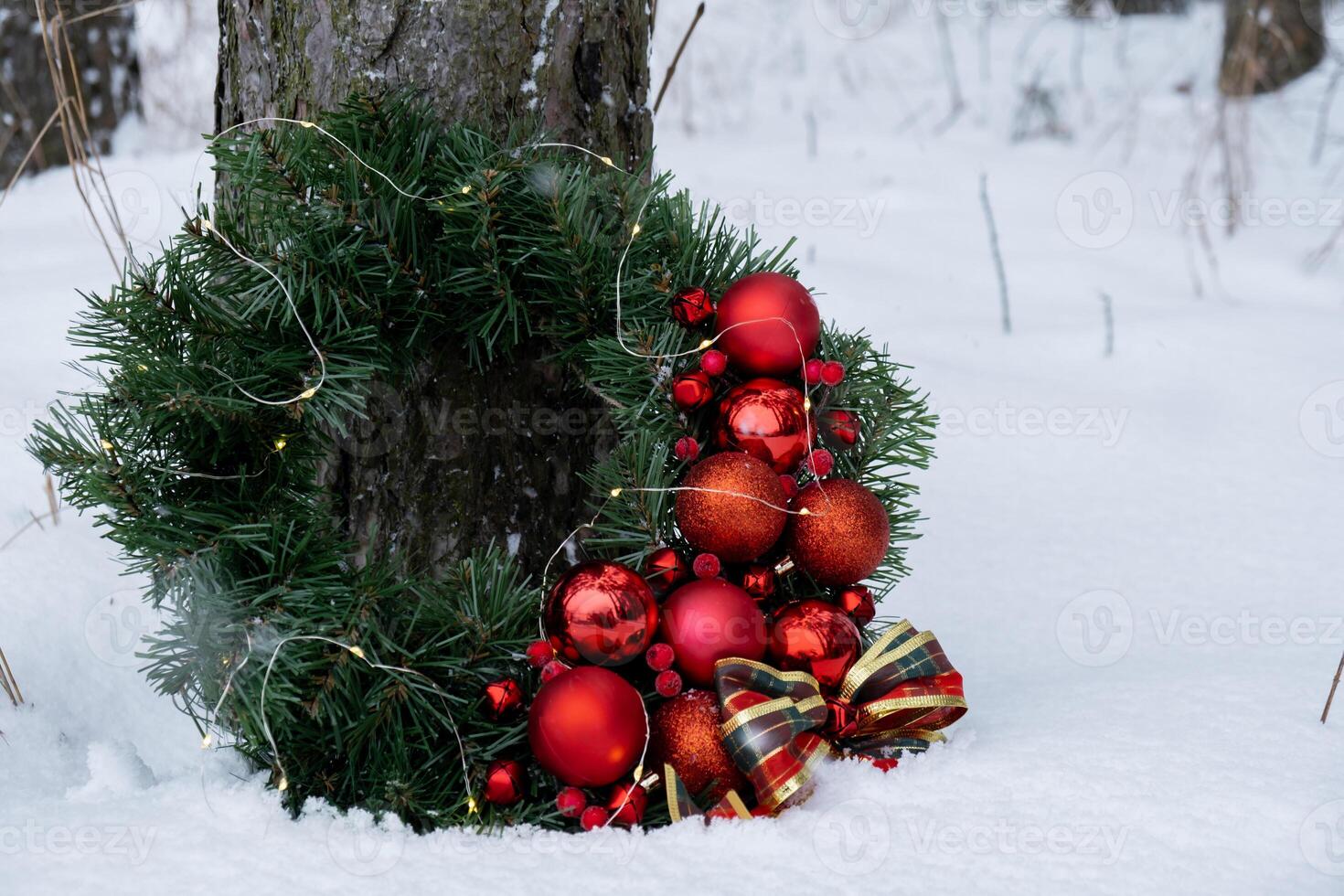 Handmade Christmas wreath from red decorations. Festive holiday preparation outdoors in winter snowy weather. Sustainable responsible holiday gift creation. Copy space photo