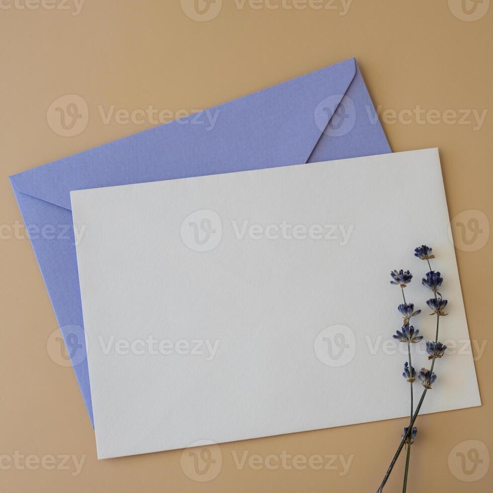 Empty white envelope paper card note template mock up. Copy space for your text. Lavender flower. Greeting or invitation card blank with envelope. Top view, flat lay photo
