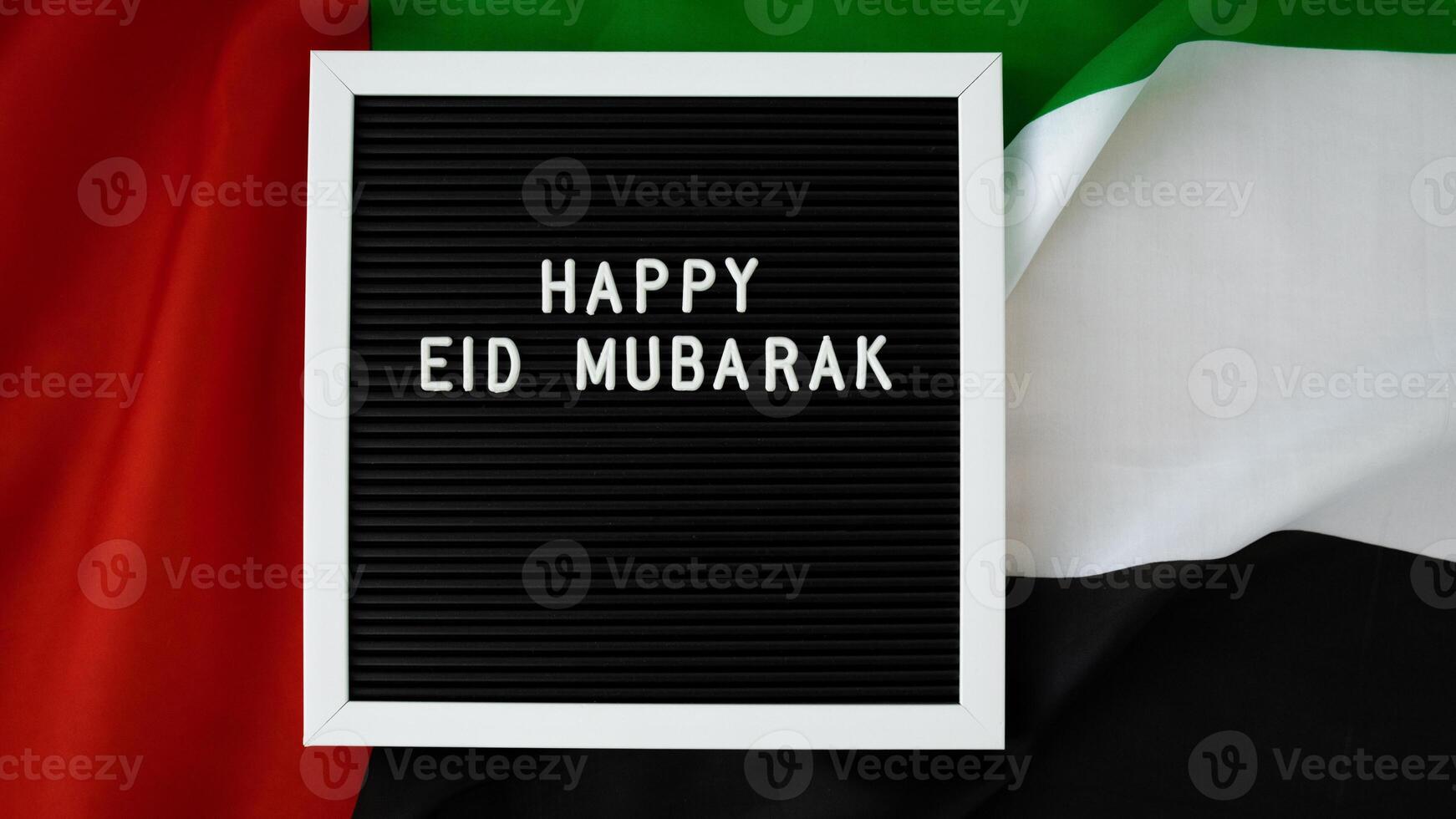 Message text HAPPY EID MUBARAK - happy holidays waving UAE flag on background concept. Greeting card advertisement. Commemoration Day Muslim Ramadan Blessed holy month public holiday. Patriotism photo