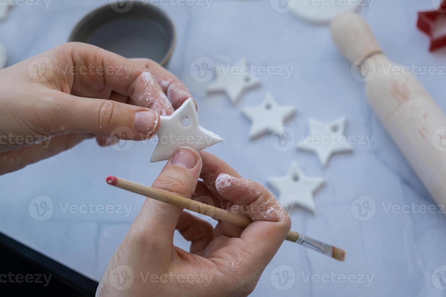 Christmas star Creator is using white air dry clay for making decor to Christmas tree holiday. Creating hobby recreation activity that involves fingers. DIY crafting Modern art photo