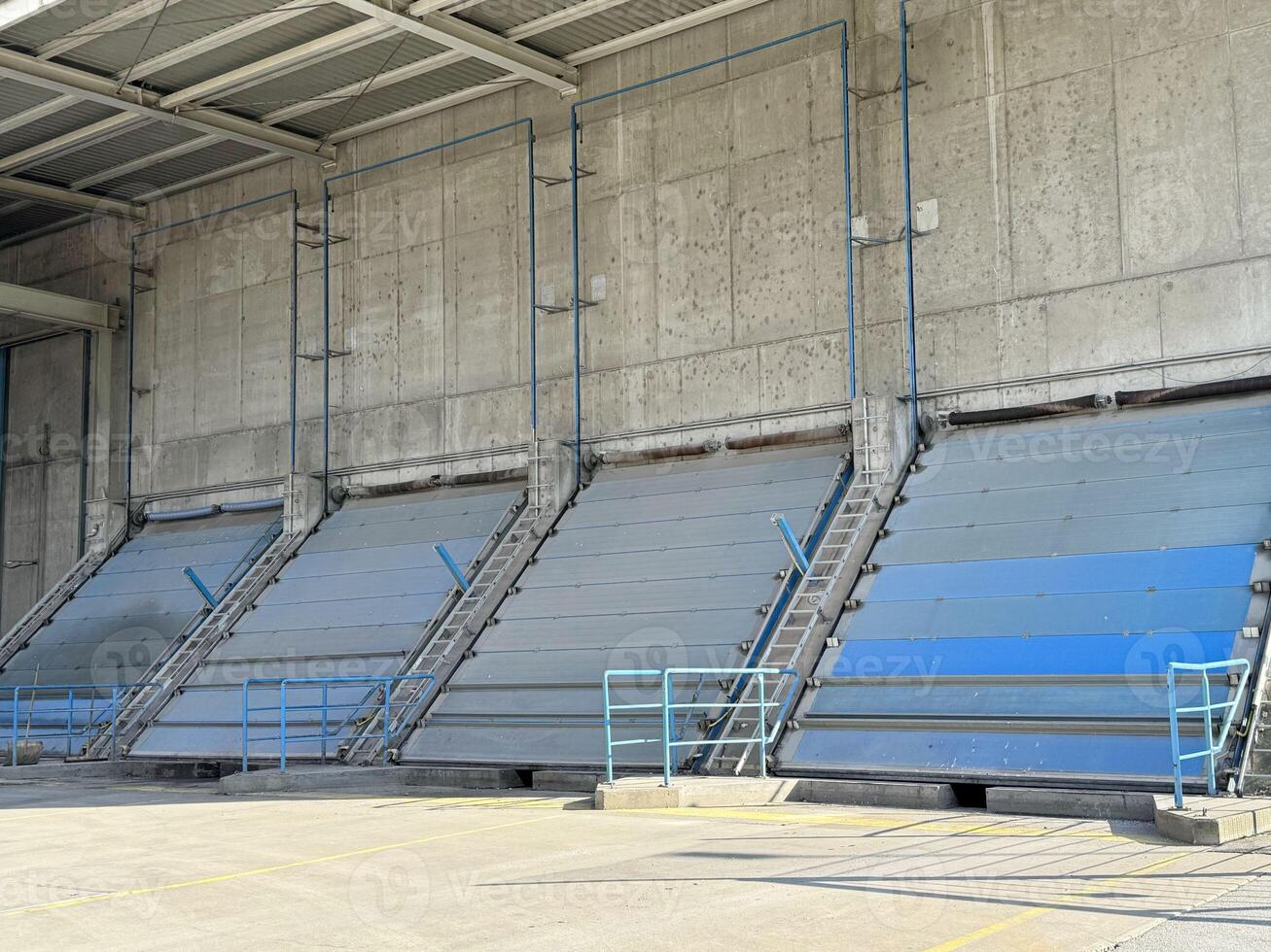 Industrial loading dock with closed cargo bay doors under sunlight photo