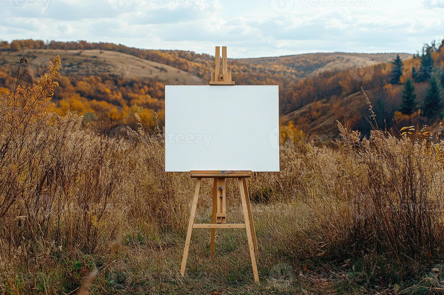 Wooden easel with blank canvas in beautiful autumn landscape inspiring creativity photo