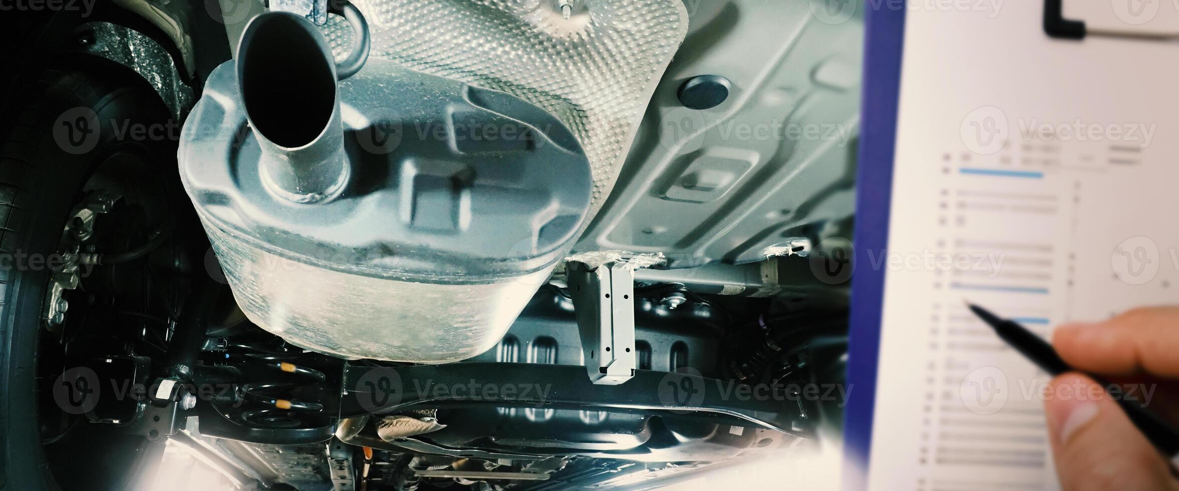 Under car exhaust pipe and suspension. Automotive mufflers. Inspection of car for Defects. Metal fittings and pipes for the muffler. Suspension elements and exhaust system. Auto parts and car service photo