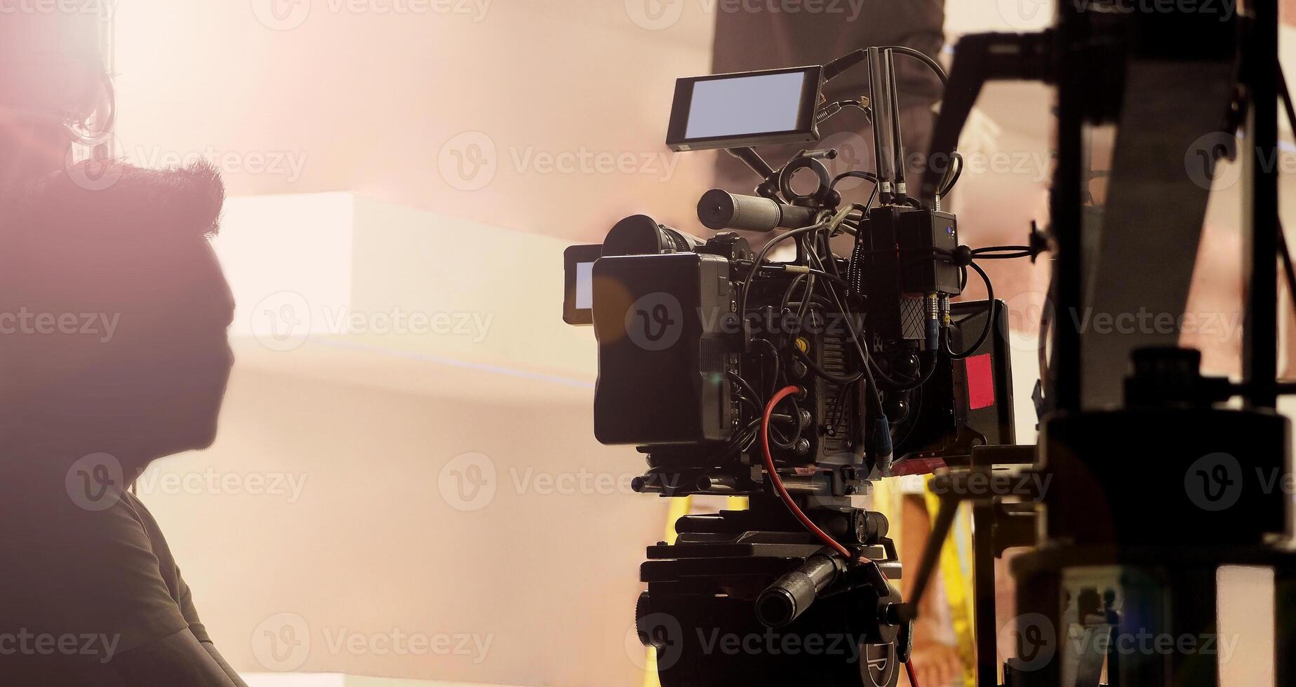 Filmmaker crew team with professional cinema equipment and film camera on the set. Film director and crew making commercial content advertising in studio. Technique of modern filming and advertising. photo