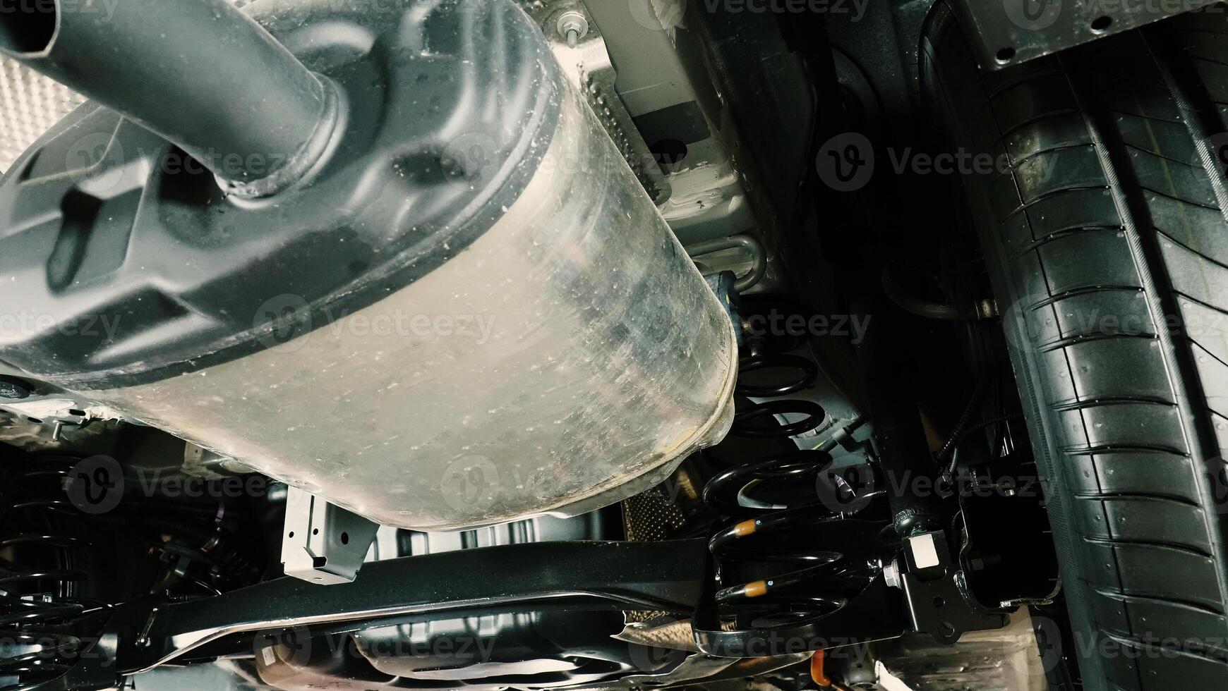 Under car exhaust pipe and suspension. Automotive mufflers. Inspection of car for Defects. Metal fittings and pipes for the muffler. Suspension elements and exhaust system. Auto parts and car service photo