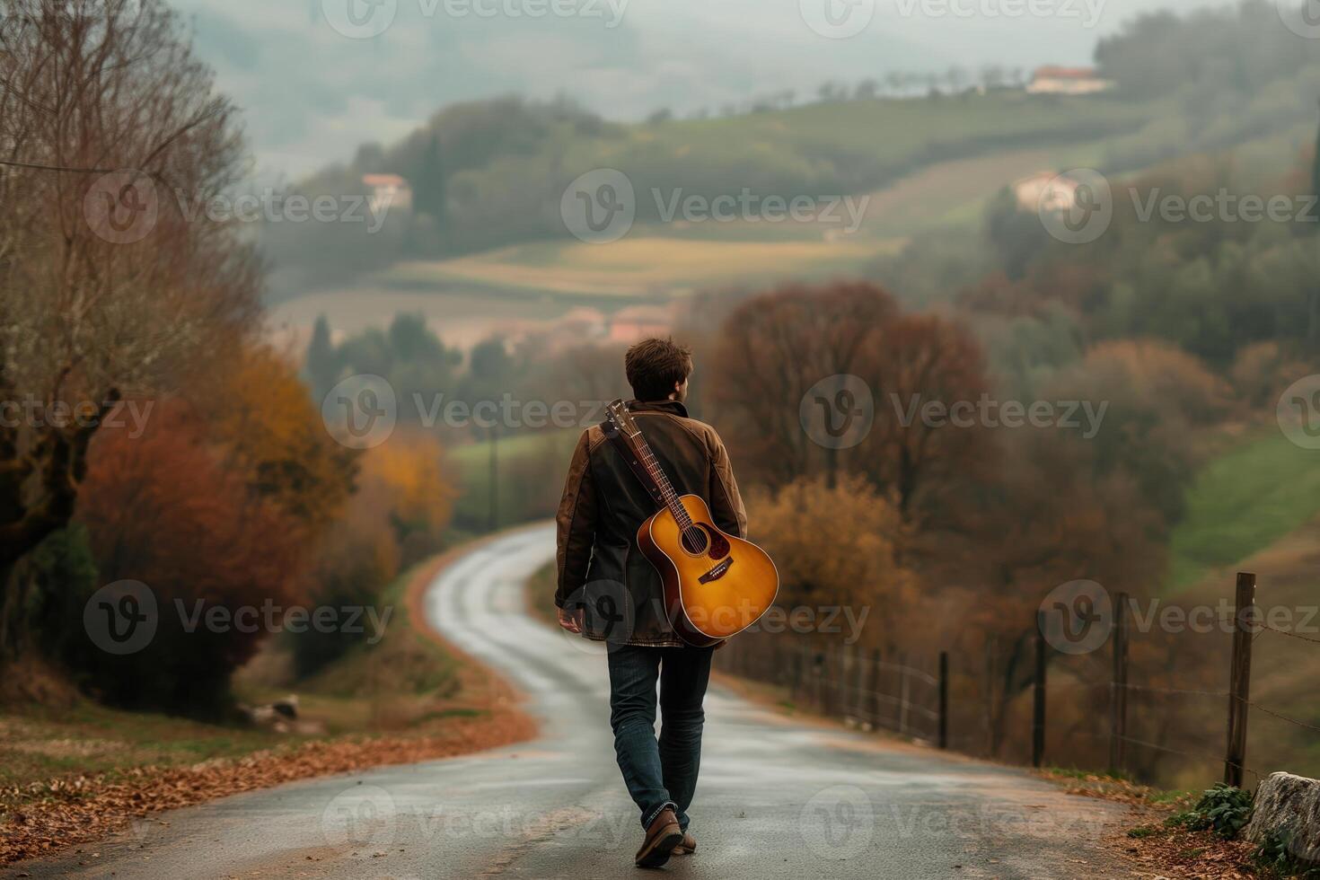 a man with a guitar case on his back walks along a picturesque road, rear view photo