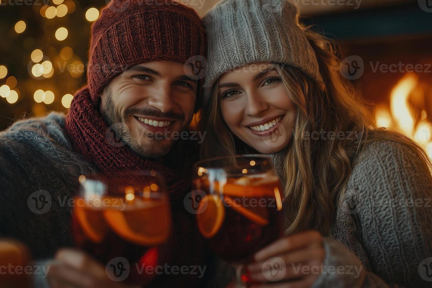 a couple holding glasses of wine in front of a fireplace photo
