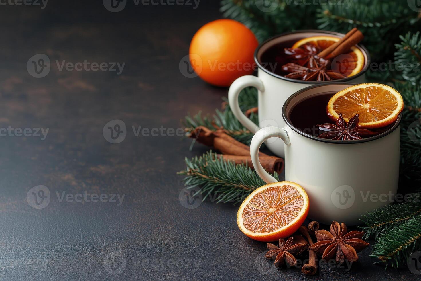 Mulled wine in white metal mugs with cinnamon and orange slice on festive background. Copy space for text photo