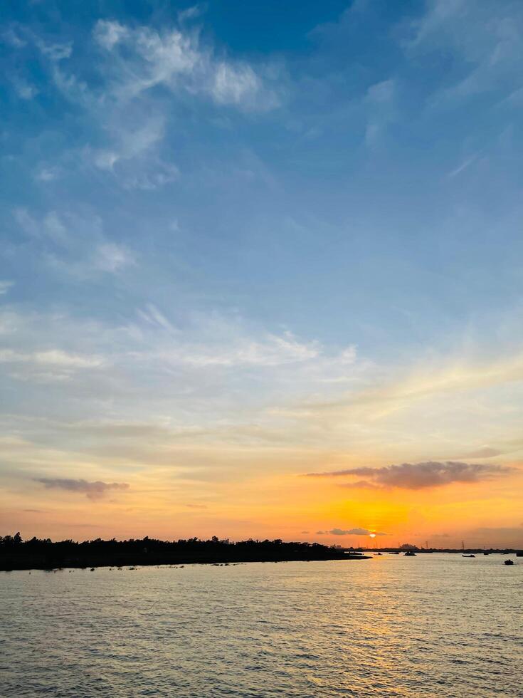 A sunset view of a river and a river with clouds in the sky photo