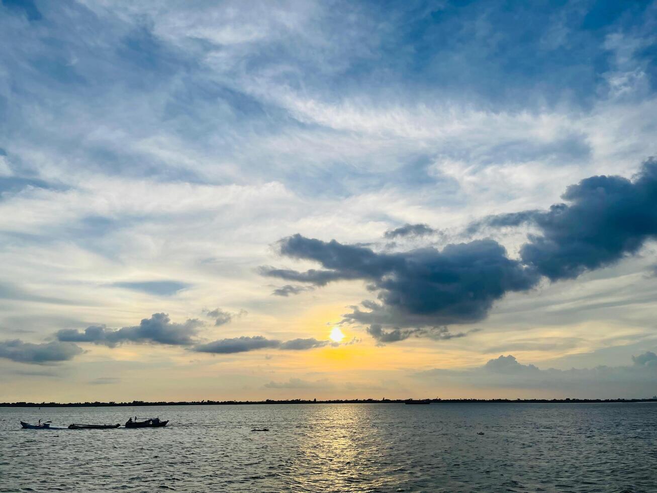 A sunset view of a river and a river with clouds in the sky photo
