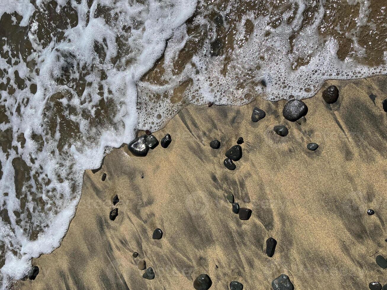 Sea water foam on the shore with sand and pebbles. Abstract seascape background wallpaper with copy space photo