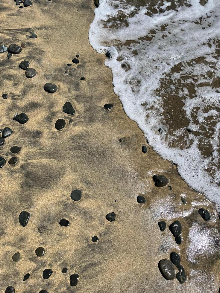 Sea water foam on the shore with sand and pebbles. Abstract seascape background wallpaper with copy space photo