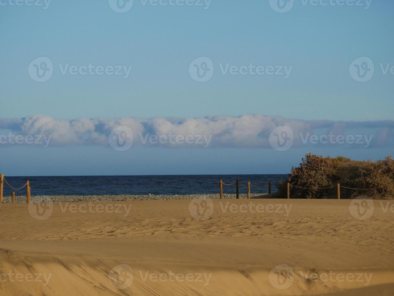 Sandy beach in Maspalomas, Gran Canaria at dusk with cloudy sky. Seascape background wallpaper with copy space photo