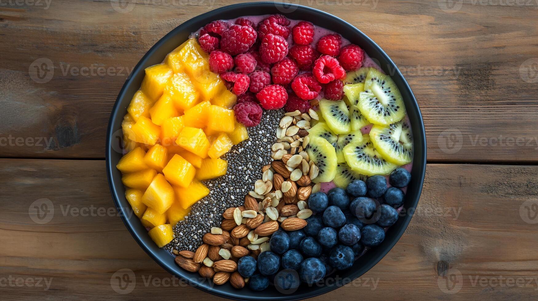 A bowl of fruit and nuts on a wooden table photo