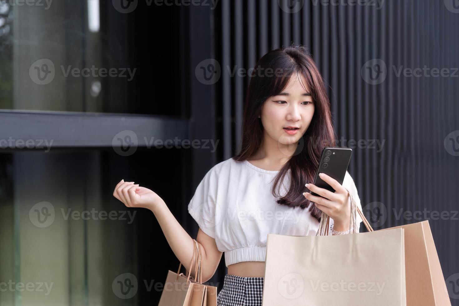 Young Woman Enjoying a Shopping Spree with Paper Bags in a Modern Shopping Mall Environment photo