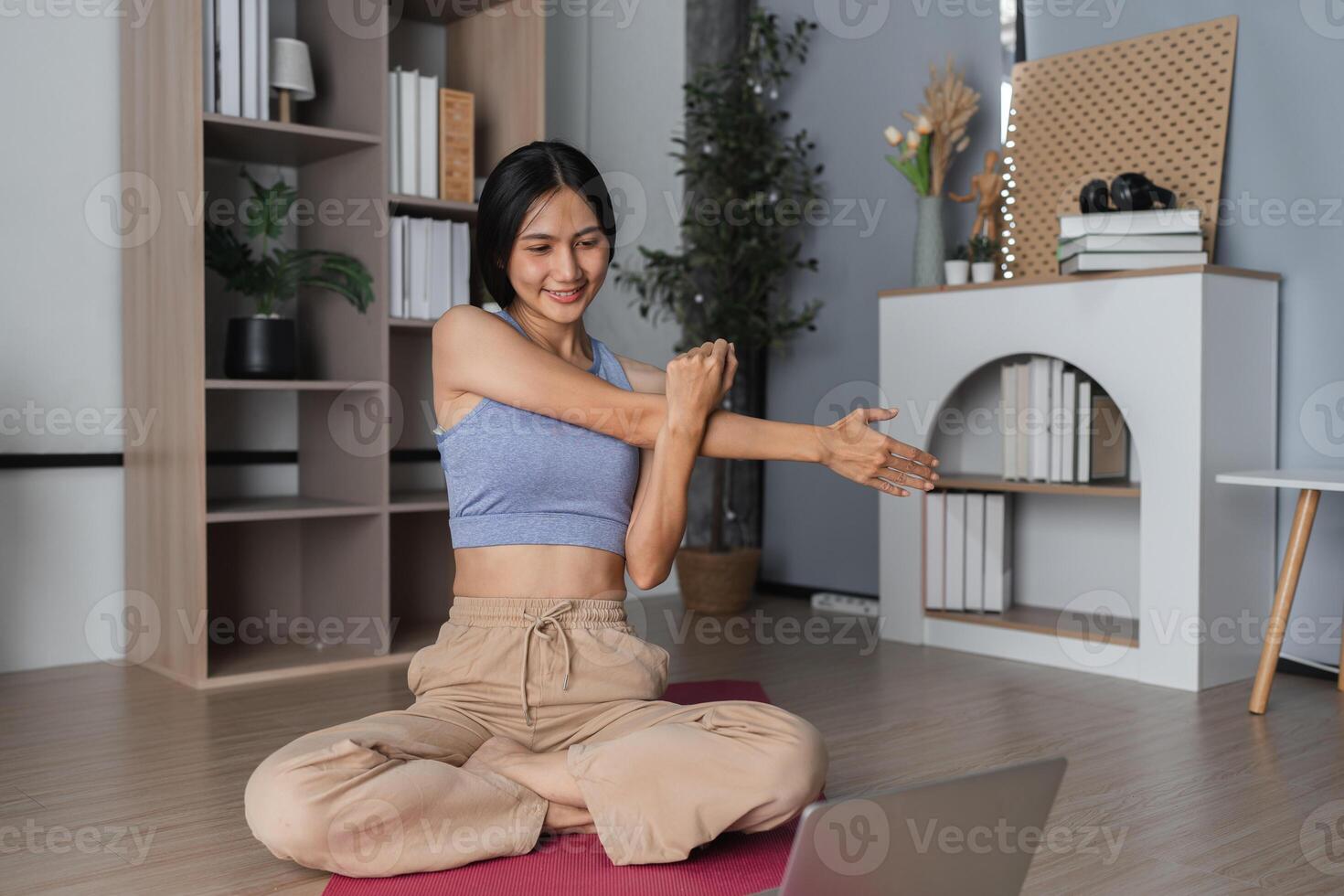 Young Woman Practicing Yoga Indoors, Stretching Muscles in a Modern Home Setting for Relaxation and Fitness photo