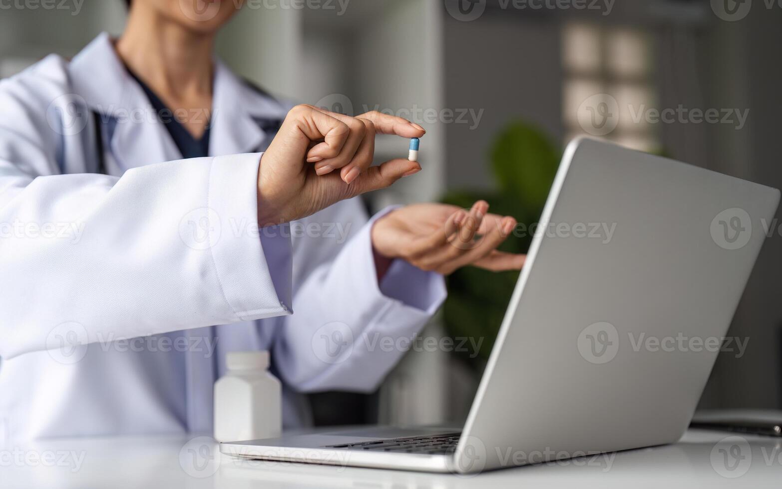 Female Doctor Providing Online Medical Advice with Laptop and Medication in Modern Healthcare Setting photo