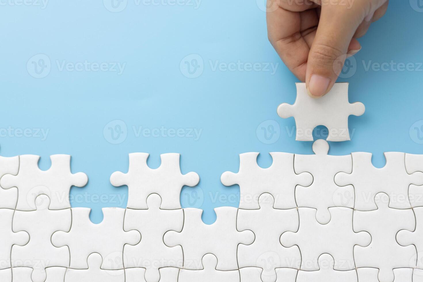 Hand push last piece jigsawto finish success planning concept solve puzzle, logical thinking, Concept of challenge and determination as the person works to complete the puzzle. photo