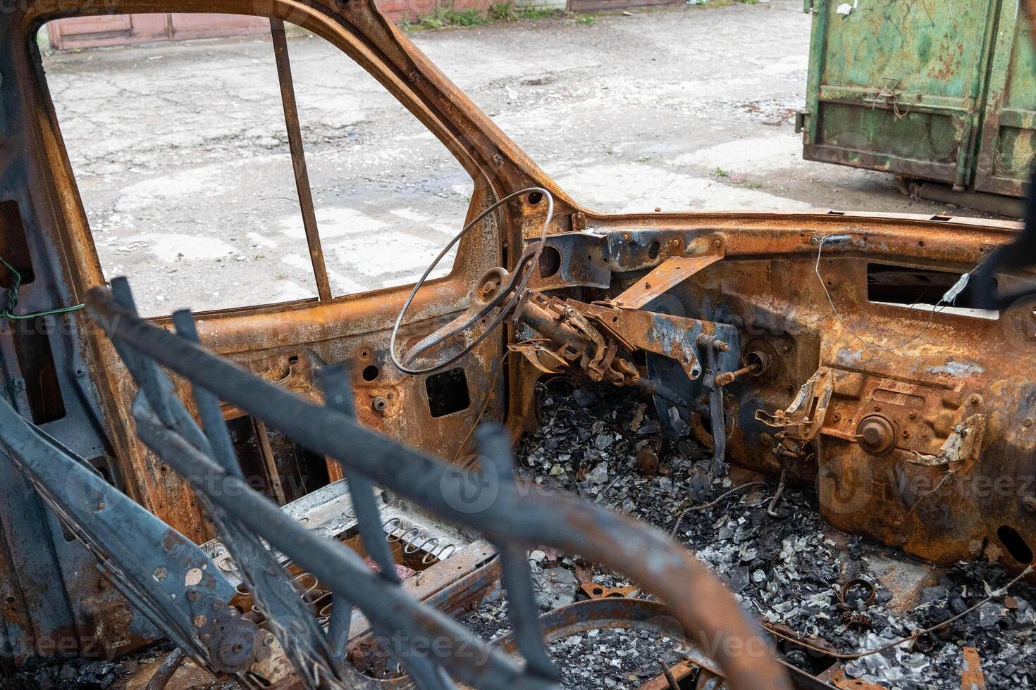 Rusty destroyed car interior with broken steering wheel photo
