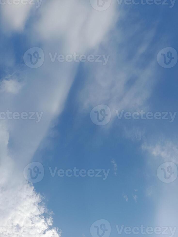 White clouds in the blue sky. Beautiful bright blue background. Light cloudy, good weather. Curly clouds on a sunny day. photo