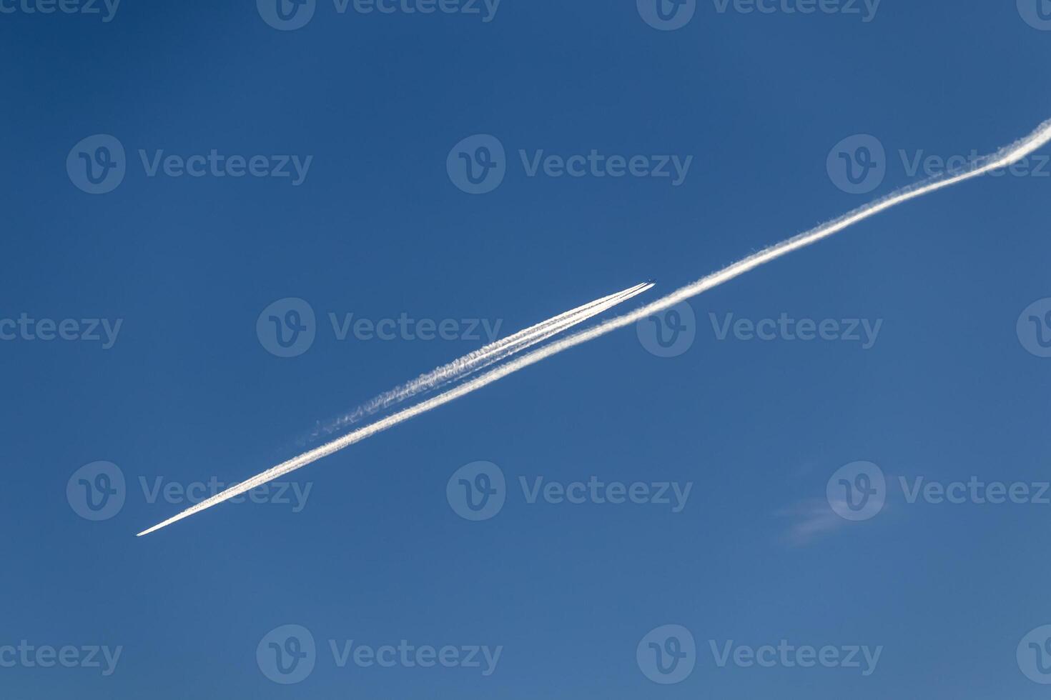 Contrails - two planes flying in opposite directions with condensation trails photo
