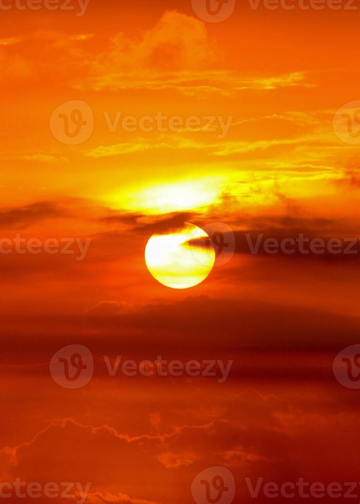 A beautiful sunset over the ocean with clouds in the background photo