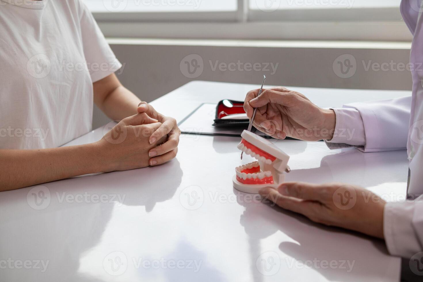 woman consults dentist about her toothache for treatment in dental clinic and dentist gives advice on right symptoms and treatment method for patient. concept consulting dentist about dental treatment photo