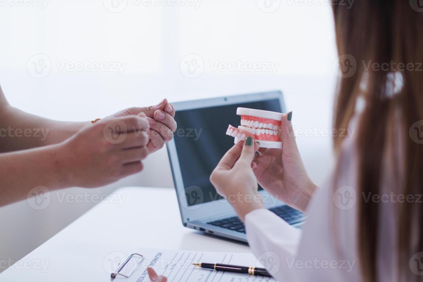 woman consults dentist about her toothache for treatment in dental clinic and dentist gives advice on right symptoms and treatment method for patient. concept consulting dentist about dental treatment photo