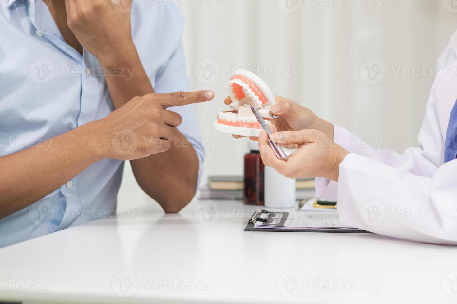 woman consults dentist about her toothache for treatment in dental clinic and dentist gives advice on right symptoms and treatment method for patient. concept consulting dentist about dental treatment photo
