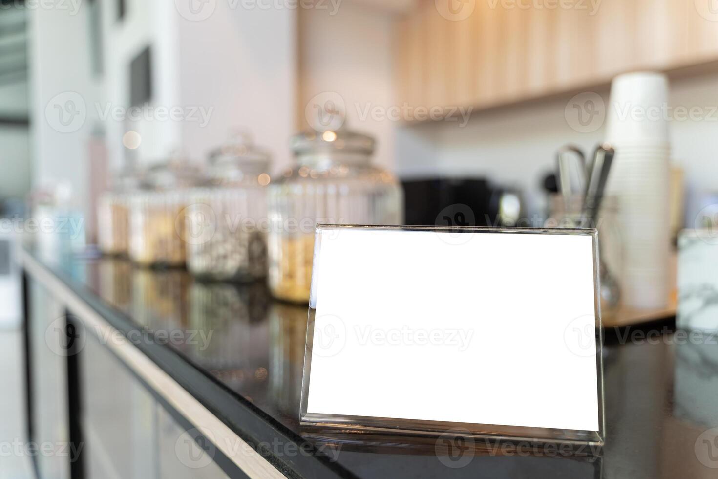Mock up menu frame on table in cafe bar. Menu frame mockup in bar restaurant, stand for booklet with white sheet of paper, acrylic tent card on wooden table on cafeteria. photo